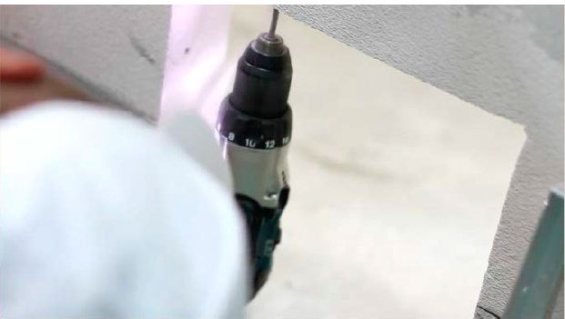 Вынимаем раму из проема. По нанесенным меткам сверлим отверстия в ребрах проема